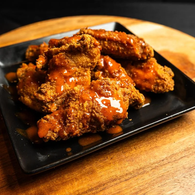 Crispy wings tossed in house hot sauce
